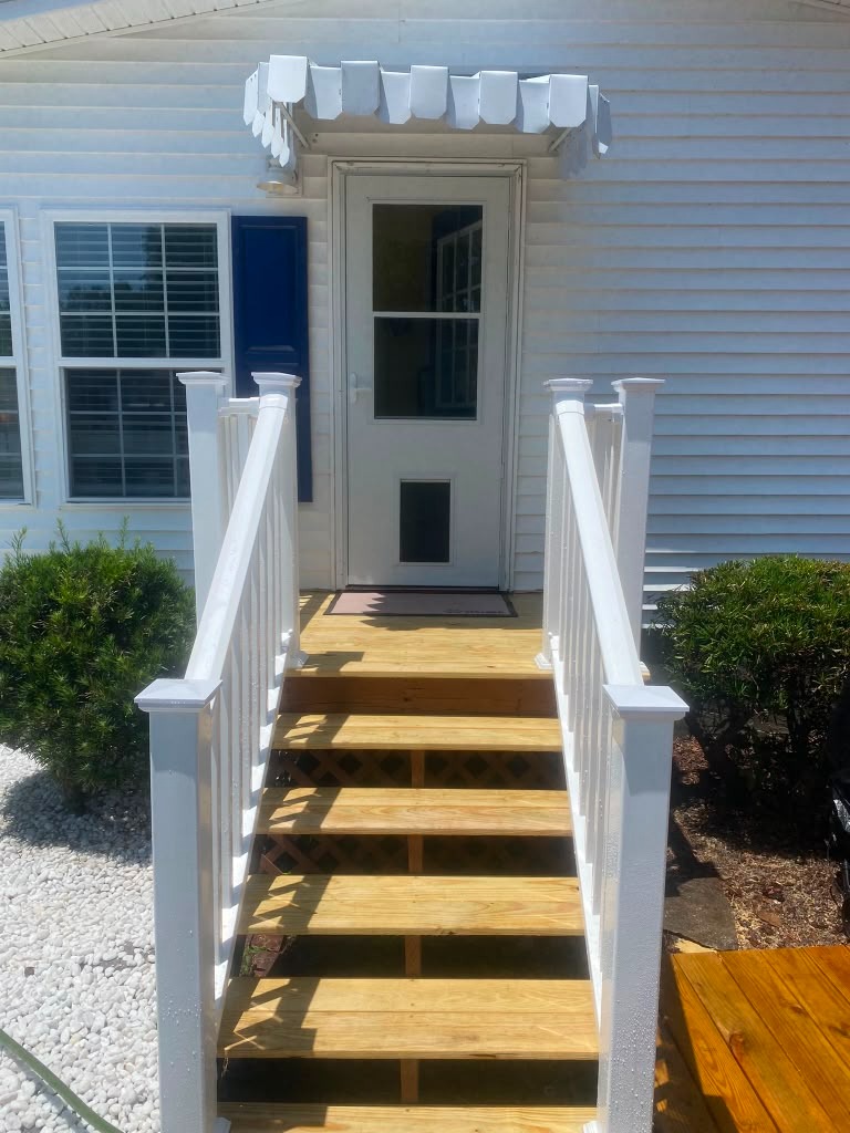 Renovated front entry steps with white railings completed by Handysam