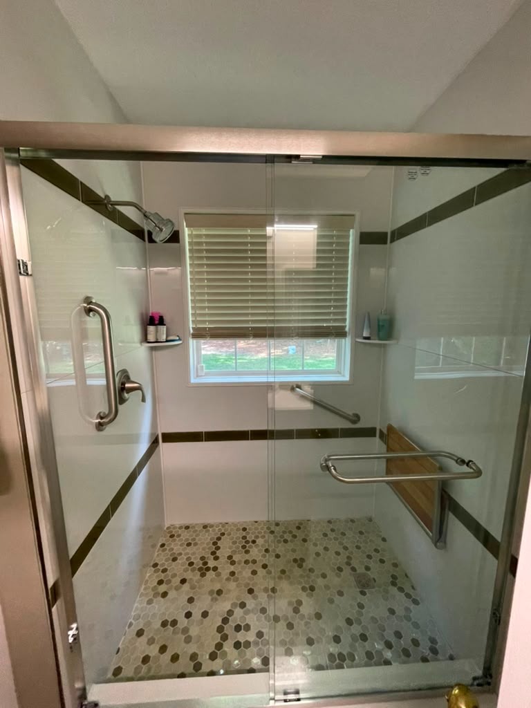 Completed shower remodel with glass enclosure and grab bars by Handysam