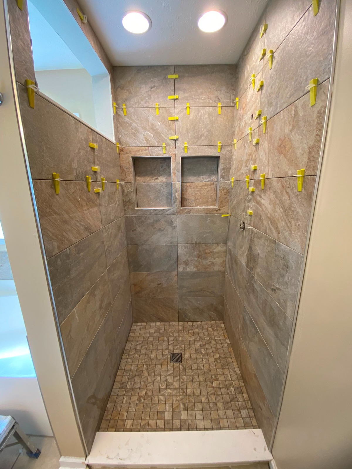 Large-format shower tile being installed by Handysam